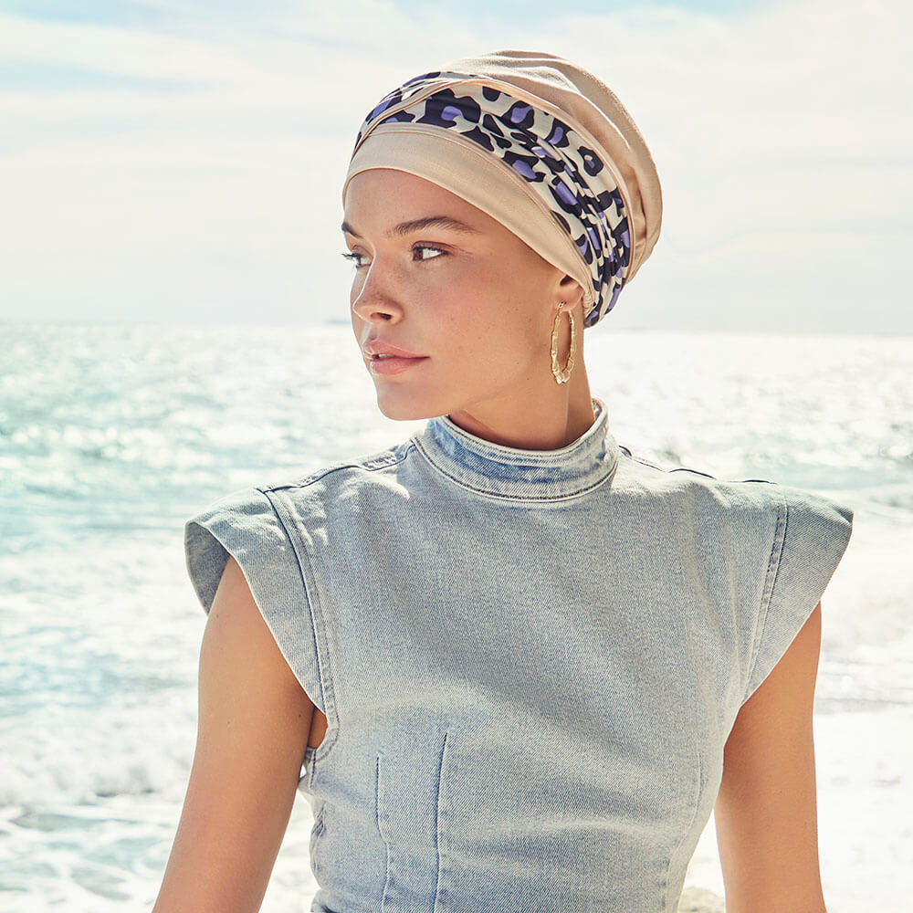 Emmy Turban i sandfarve med lilla leopard pandebånd.