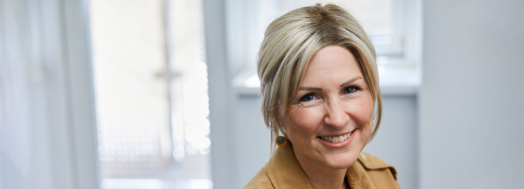 Kvinde med paryk. Parykken er fremstilling i lyst fiberhår med høj kvalitet.