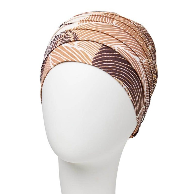Enkelt turban med små lag, giver en enkelt fylde. Tørklædet har råhvid base med mønster i brune nuancer.