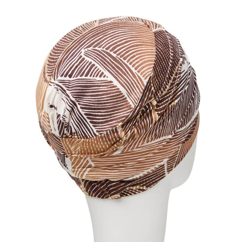 Enkelt turban med små lag, giver en enkelt fylde. Tørklædet har råhvid base med mønster i brune nuancer.
