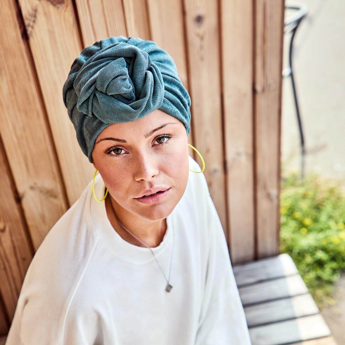Smuk petroliumsblå turban med en blomst i panden
