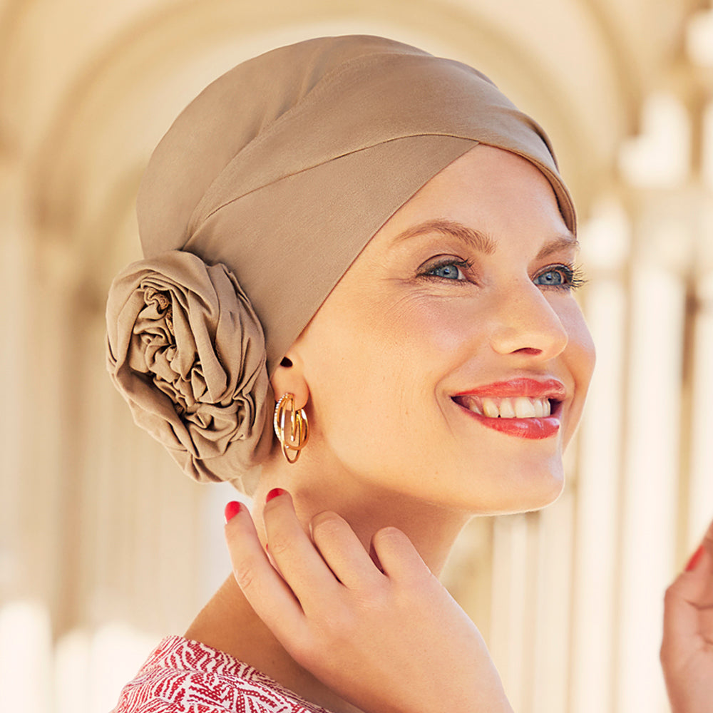 Smuk turban med rosette, der giver naturlig fylde. Turbanen har den fine og bløde sandfarve.