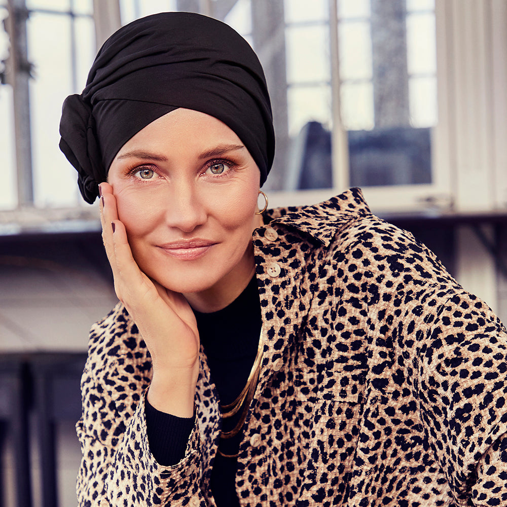 Smuk turban med rosette, der giver naturlig fylde. Turbanen er sort.