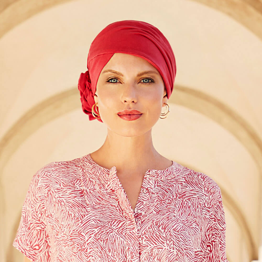 Smuk turban med rosette, der giver naturlig fylde. Turbanen har den fineste koralrøde farve.